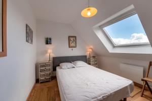 a bedroom with a large bed and a window at La maison aux volets bleus in Arzon