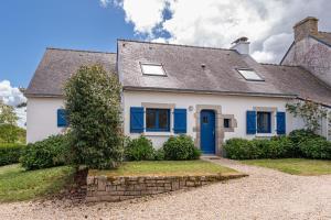 a white house with blue shutters at La maison aux volets bleus in Arzon