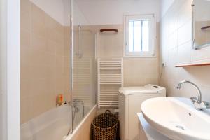a bathroom with a sink and a tub and a toilet at La maison aux volets bleus in Arzon +15 photos