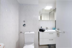 ein weißes Bad mit einem WC und einem Waschbecken in der Unterkunft Panorama Schönberg 02 in Stakendorfer Strand