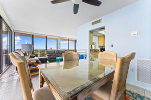 a dining room with a glass table and chairs at Our House at the Beach 502E By Beachside Management in Siesta Key +32 photos
