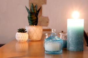 Una mesa con una vela y unos jarrones. en La perla casa vacanze en Barletta