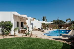 a villa with a swimming pool and a yard at The Carobs Villas in Carvoeiro