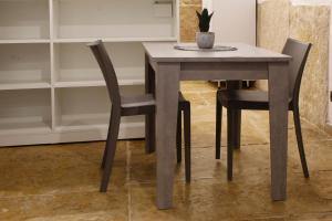 a dining room table with two chairs and a potted plant at La perla casa vacanze in Barletta +2 photos