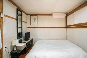 a bedroom with a bed and a desk with a computer at NamHyunDang - Hanok Korean Traditional House in Seoul