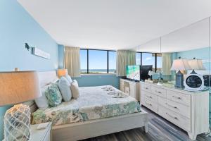 1 dormitorio con 1 cama y escritorio con TV en Our House at the Beach 604E, en Siesta Key