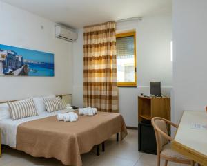 Schlafzimmer mit einem Bett, einem Schreibtisch und einem Fenster in der Unterkunft Hotel Santa Lucia in Santa Cesarea Terme