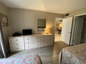 a bedroom with a bed and a dresser with a mirror at Palm Bay Club in Siesta Key