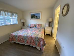 a bedroom with a bed and two night stands and a window at Palm Bay Club in Siesta Key
