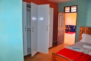 1 dormitorio con 1 cama y 1 dormitorio con puerta en Shanzu Budget Traveler Homestay, en Mombasa