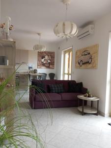 Il comprend un salon avec un canapé violet et une cuisine. dans l'établissement casa norvegese, à Pizzo