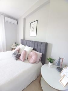 a bedroom with a bed with pink pillows and a table at Feliz Algarve in Albufeira