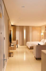 um quarto de hotel com uma cama e um sofá em Blend Hotel em Dammam
