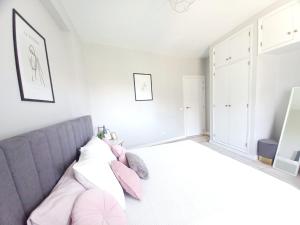 a bedroom with a gray couch and pink pillows at Feliz Algarve in Albufeira