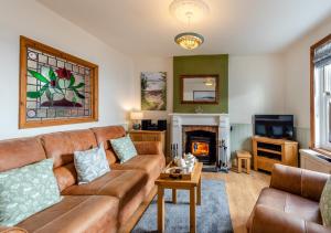 a living room with a couch and a fireplace at Wellies in Appledore