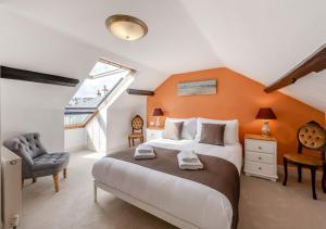 um quarto com uma cama grande e uma parede laranja em Wellies em Appledore