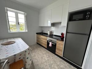 une cuisine avec un réfrigérateur et une table à l'intérieur dans l'établissement Casa A Gateira, à O Casal Pontevedra 12 autres photos
