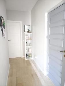 a hallway with a white door and a book shelf at Feliz Algarve in Albufeira
