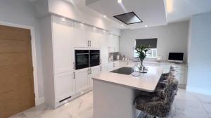 a large kitchen with white cabinets and a counter at Great holiday home for vacations & holidays in Tetney