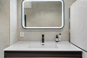 a bathroom with a sink and a mirror at Experience the luxury lifestyle 100m from Bryggen! in Bergen +19 photos
