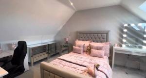 a bedroom with a large bed with pink pillows at Great holiday home for vacations & holidays in Tetney
