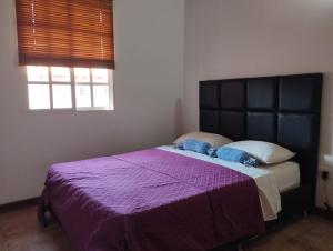 a bedroom with a large purple bed with two pillows at Villa Martinica in El Morro de Barcelona
