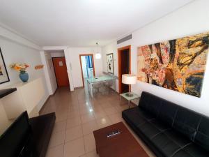- un salon avec un canapé et un tableau mural dans l'établissement Patacona Resort Apartments Primera Linea, à Valence