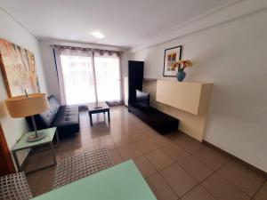 a living room with a couch and a table at Patacona Resort Apartments Primera Linea in Valencia