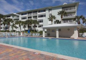 a hotel with a swimming pool in front of a building at Sun and Sea By Beachside Management in Siesta Key