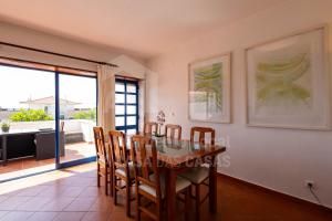 a dining room with a table and chairs and a balcony at Casa do Sol by AcasaDasCasas in Ericeira