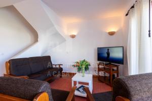 a living room with a couch and a tv at Casa do Sol by AcasaDasCasas in Ericeira