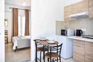 a small kitchen with a small table and chairs at Green View Apartments in Kouspádes