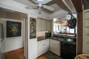 a kitchen with white cabinets and a ceiling fan at Fanta-Sea 47 By Beachside Management in Siesta Key
