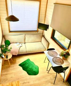 a living room with a couch and a table at Tiny house with garden and jacuzzi near Amsterdam in Vijfhuizen