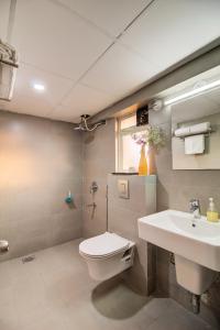 een badkamer met een toilet en een wastafel bij Housemate Hotel in Pune