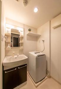 een badkamer met een wastafel en een spiegel bij Eight Residence Osaka in Osaka