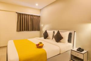 a bedroom with a bed with a basket of fruit on it at Housemate Hotel in Pune