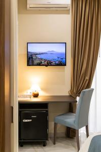 a room with a desk with a television on a wall at Station House 45 in Naples