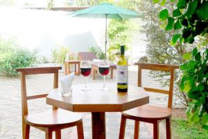 a table with two glasses of wine and an umbrella at Villa L 24 in Dickwella