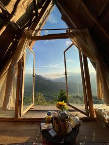 a table with a tea set in front of a window at Imani Eco Sky Lodge Ngoc Chien in Nam San