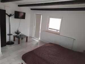a bedroom with a bed and a window and a table at CASA FLOARE DE COLT in Stațiunea Climaterică Sâmbăta