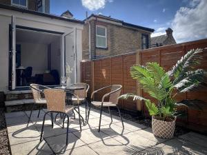 a patio with chairs and a table and a plant at Campbells Crib in Kent