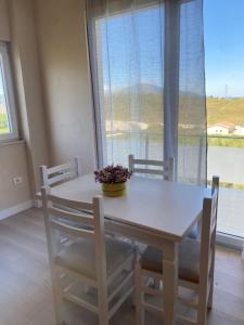a dining room table and chairs with a window at Vila Bakalli in Vlorë