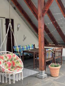 eine Veranda mit einer Schaukel, einem Tisch und Stühlen in der Unterkunft Apartament 27 z tarasem in Jelenia Góra + 16 Fotos