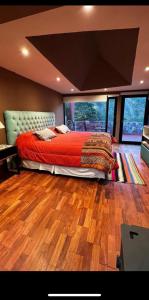 1 dormitorio con 1 cama en una habitación con suelo de madera en Santuyoc Lodge en Volcán