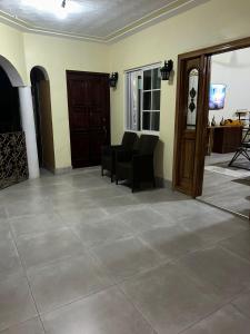 a living room with a tiled floor and chairs at White House by White River in Ocho Rios