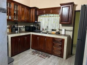a kitchen with wooden cabinets and a sink at White House by White River in Ocho Rios