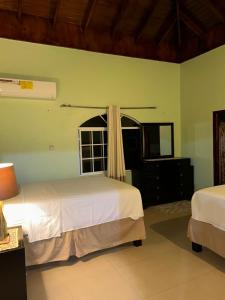 a bedroom with two beds and a window at White House by White River in Ocho Rios