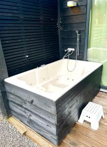 a white bath tub sitting on top of a wooden floor at Family house with garden & bubble bath & sauna near Amsterdam in Vijfhuizen