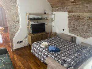 een slaapkamer met een bed, een tv en een bank bij Casa Centrale in Pisa